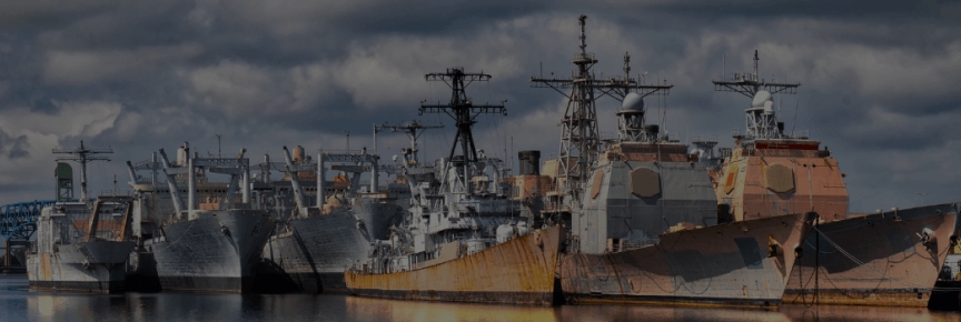 Decommissioned naval vessels, some with their hulls rusting.