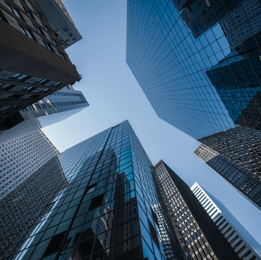 Looking up from the ground toward the sky and the glass exteriors of skyscrapers.