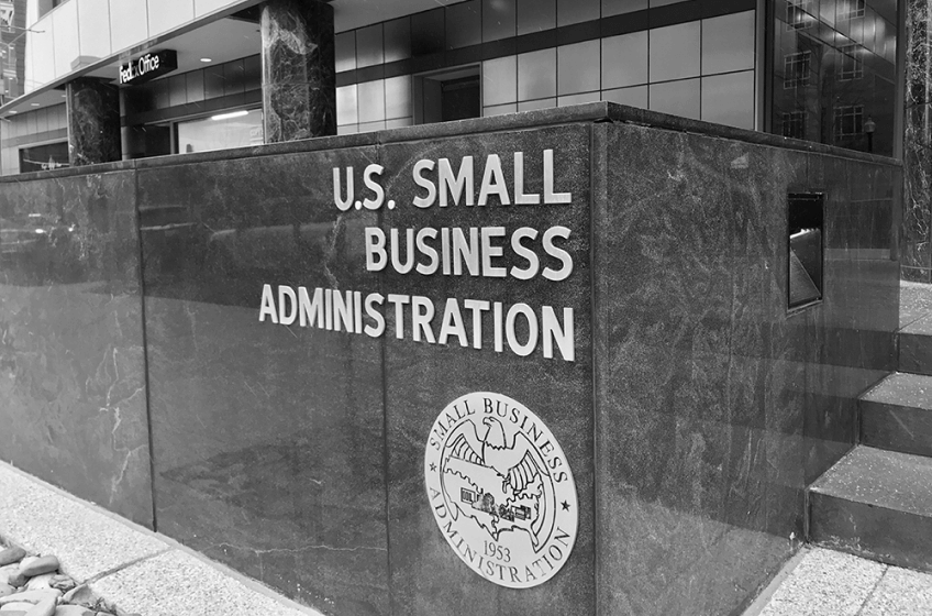 iLow marble wall outside a building. Lettering on the wall reads 