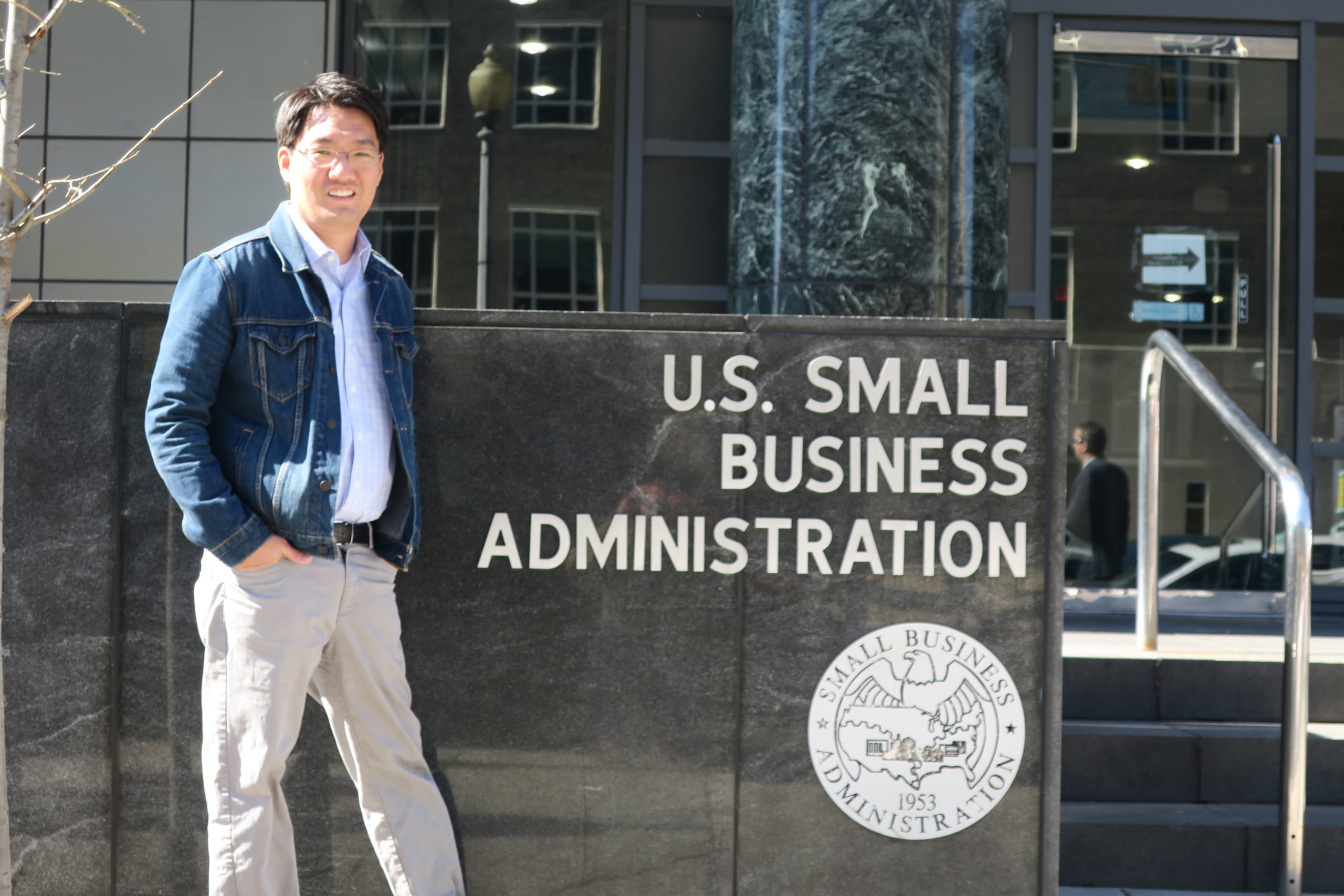 Founder and president Mitchell Cho posing in front of the US Small Business Administration building.