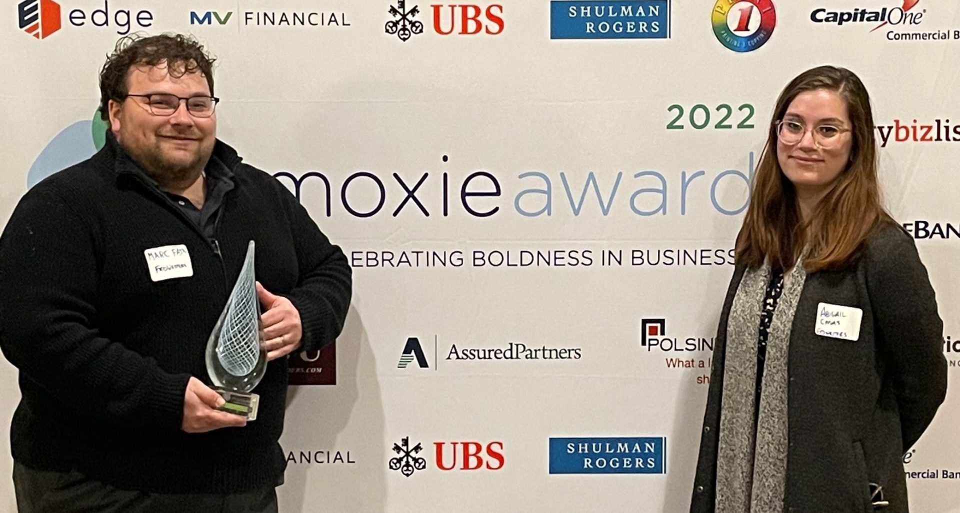 Marc Fain, holding a glass trophy, and Abigail Casas at the 2022 Moxie Awards, Celebrating Boldness in Business.