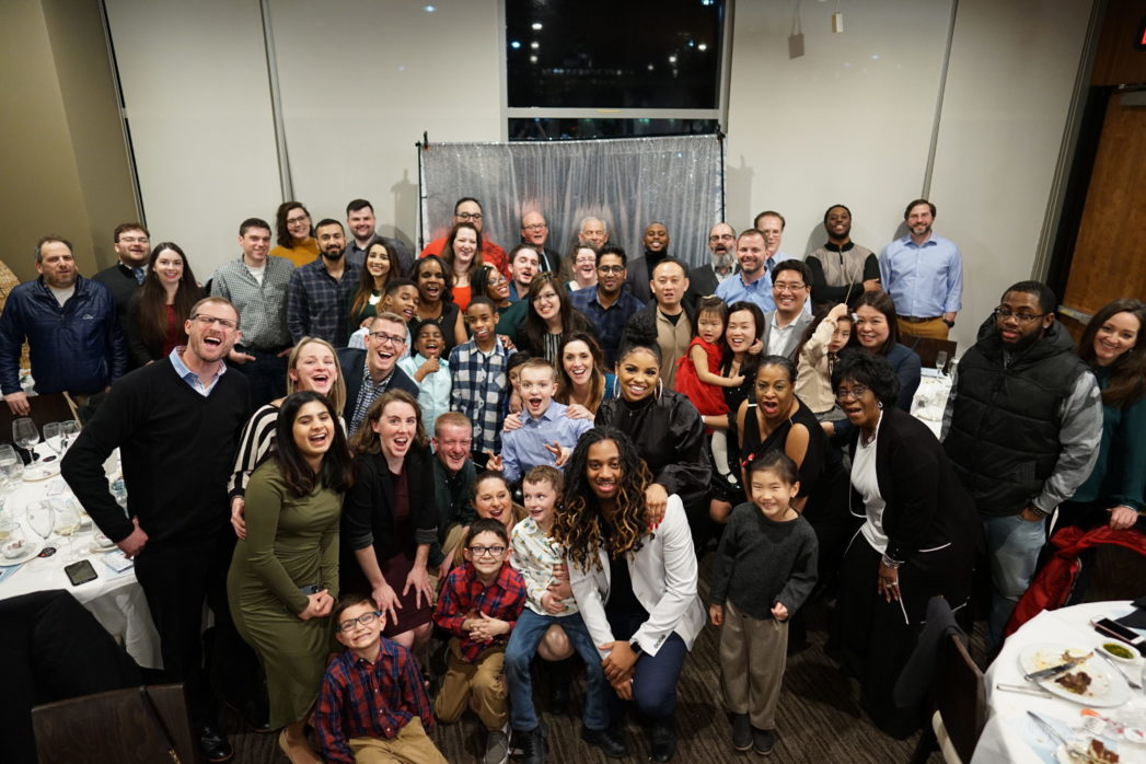 The FedWriters team and family members posing together as a large group during a holiday party.