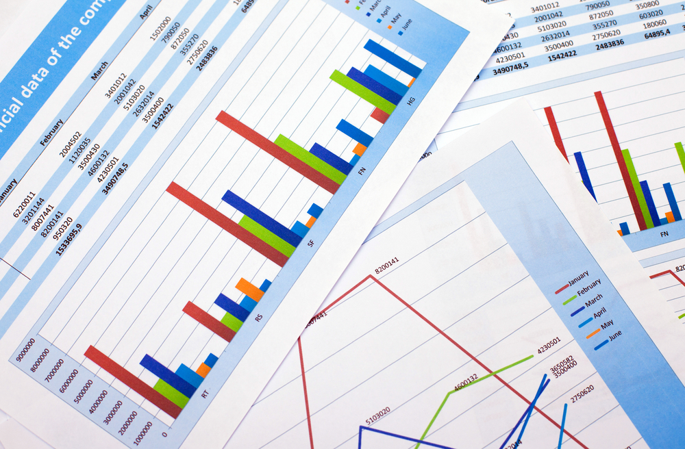 Printed pages of colorful spreadsheets overlapping each other